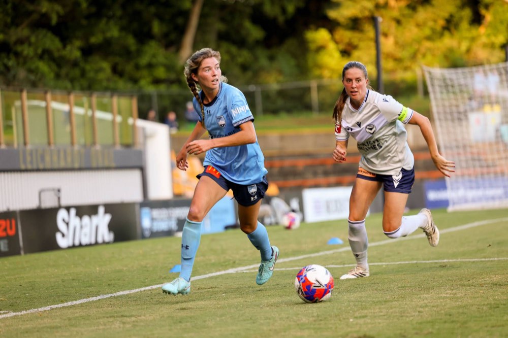 A Sydney FC player running with the ball during a match